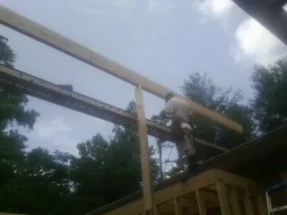 Carpenter setting a ridge beam over a new addition frame — Ice Dam Removal by Roofing Brothers in Rockdale