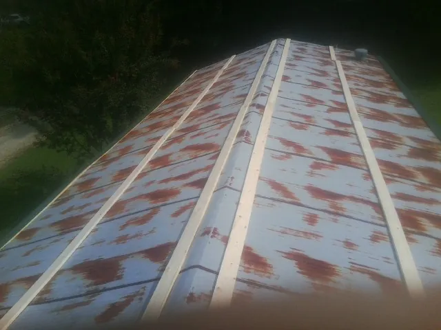 Rusted metal roof panels with new wood purlins before replacement — Storm Damage Roof Repair in Rockdale by Roofing Brothers