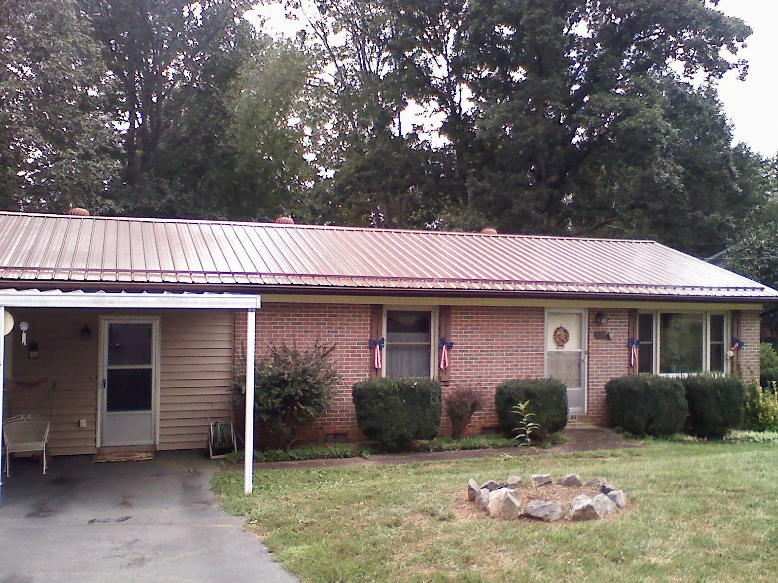 Bronze metal roof and carport on a brick ranch home — Roof Repair work by our crew in Rockdale