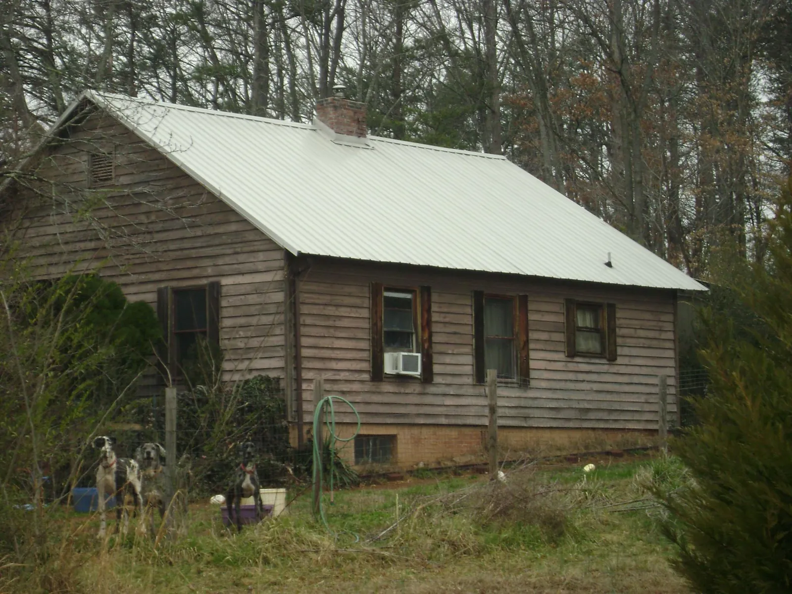White metal roof on an old wood sided farmhouse, from a Metal Roof Installation job in Rockdale